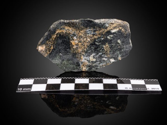 15з -Зразок № 31 (з експозиції “Самородні елементи”). Вкраплення самородного золота в діориті. Род-ще Ейршир, район Звімба, провінція Західний Машоналенд, Зімбабве. Розміри зразка 6х4х1,5 см, поч. ХХ ст., дилер W. Maucher. Фото Сергія Кадуліна